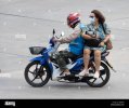 samut-prakan-tailandia-02-2022-de-abril-un-conductor-de-taxi-en-una-moto-paseos-con-una-mujer-...jpg